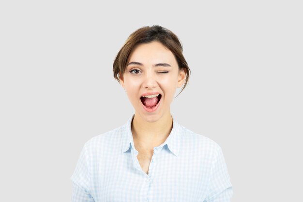 Portrait of a young beautiful woman standing and winking . High quality photo