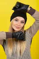 Free photo portrait of young blonde woman in black gloves and hat