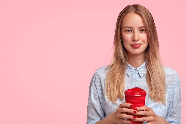 Portrait of young blonde woman holding cup of coffee