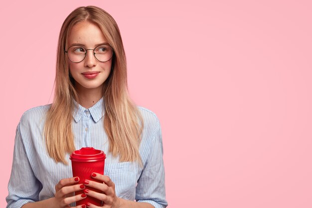 Portrait of young blonde woman holding cup of coffee