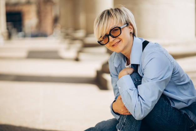 Free photo portrait of young blonde woman posing in the street