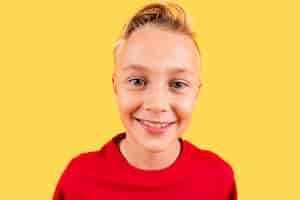 Free photo portrait young boy smiling on yellow background