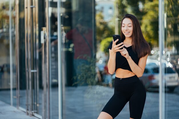 Portrait of a young brunette woman with headphones while walking