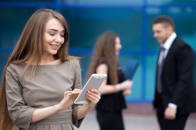 Free photo portrait of young business woman looking at tablet screen