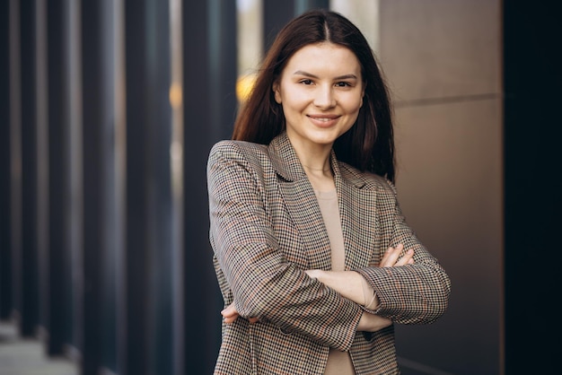 Free Photo portrait of young business woman standing bu office building