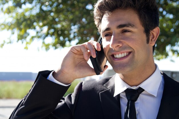 Portrait of young businessman talking with smartphone