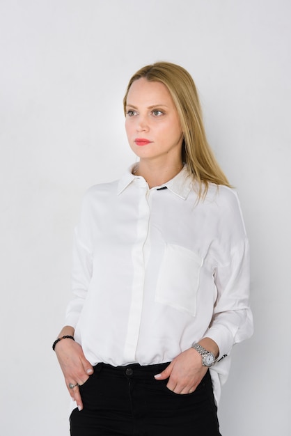 Free photo portrait of a young businesswoman with hands in the pockets isolated on white background