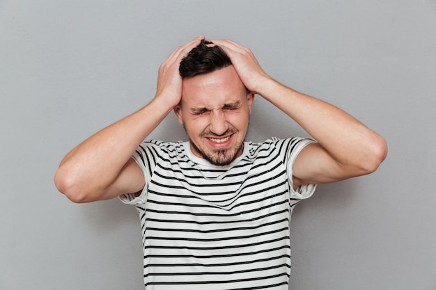 Free photo portrait of a young casual man suffering from a headache