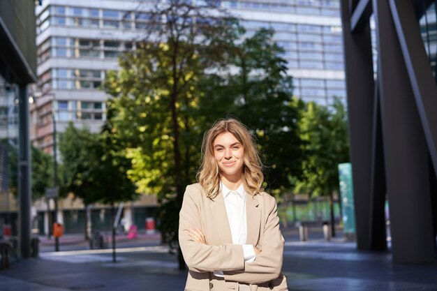 Portrait of young confident business woman in beige suit corporate lawyer or saleswoman standing out