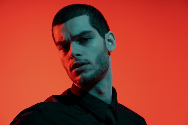 Portrait of a young confident handsome businessman in blue and red light