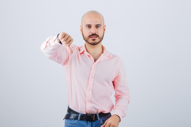 Portrait of a young confident man showing thumb down