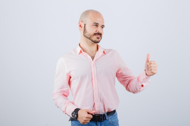 Portrait of a young confident man showing thumbs up gesture