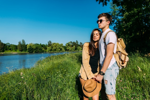 Free photo portrait of young couple standing near the lake