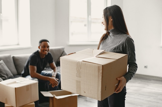 Free photo portrait of young couple with cardboard boxes at new home, moving house concept.