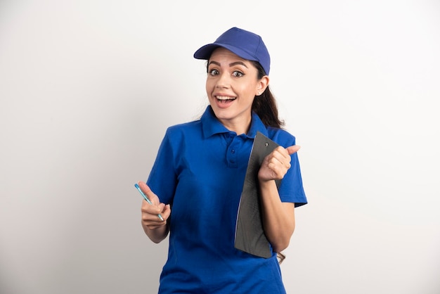 Portrait of young delivery woman with clipboard. High quality photo