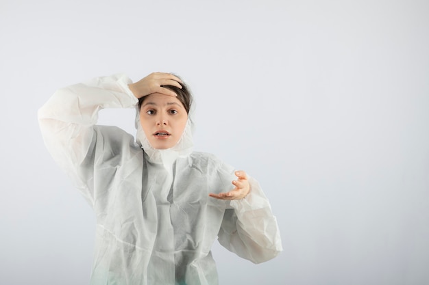 Free photo portrait of young female doctor scientist in defensive lab coat posing.