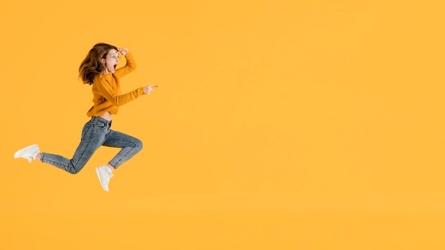 Free photo portrait young female jumping with copy space