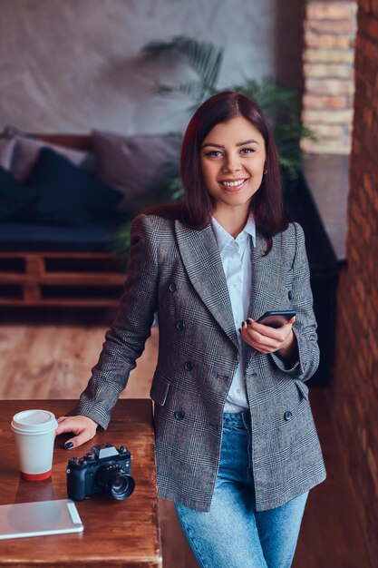 Portrait of a young female photographer works with a phone leani