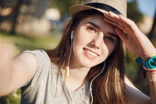 Portrait of young female tourist or student taking a selfie on a sunny day dreamin of distant locations Travel study concept