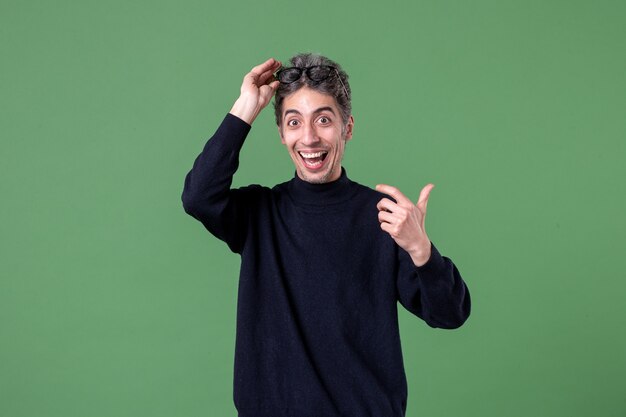 Portrait of young genius man dressed casually in studio shot on green wall