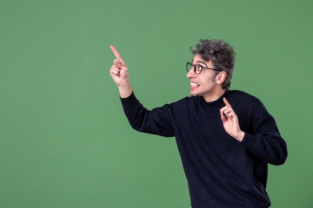 Portrait of young genius man dressed casually in studio shot on green wall