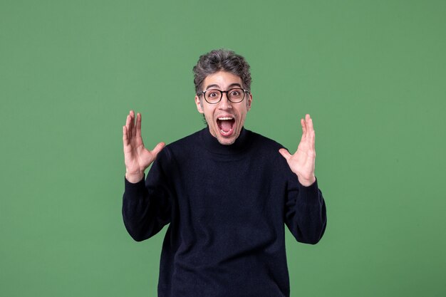 Portrait of young genius man dressed casually in studio shot on green wall