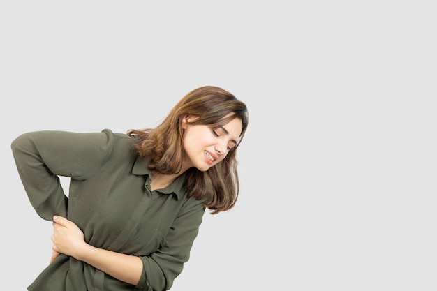 Portrait of young girl in casual outfit feeling pain in her waist. High quality photo