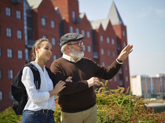 Free photo portrait of young girl embracing grandfather at park