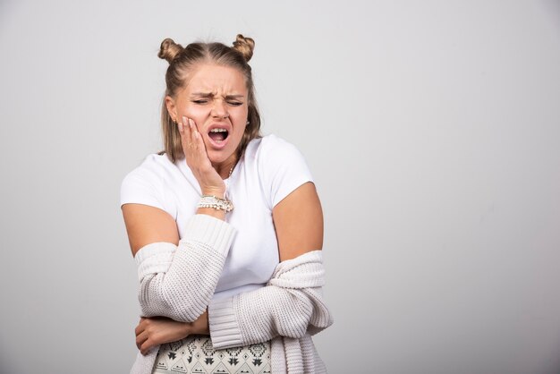 Portrait of young girl having toothache.