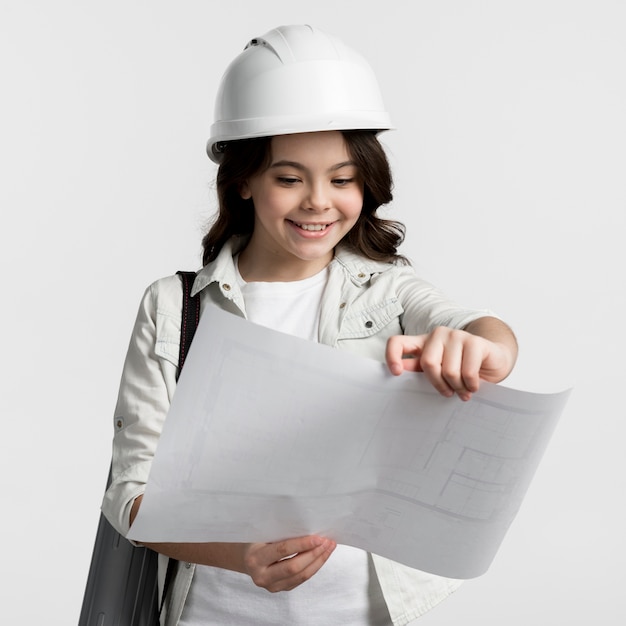 Free photo portrait of young girl reading construction plan