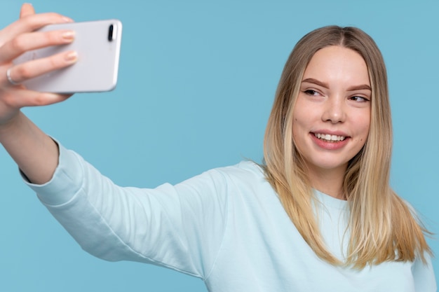 Free Photo portrait of a young girl taking a selfie