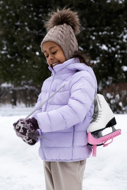 Portrait of young girl with ice skates outdoors in winter