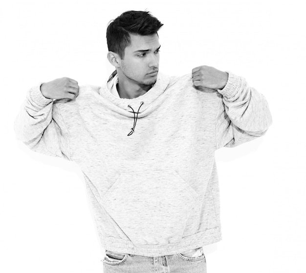 Free photo portrait of young handsome model man dressed in gray casual hoodie clothes posing on white wall. isolated