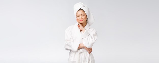 Portrait of a young happy asian lady in bathrobeIsolated in white background