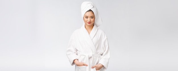 Portrait of a young happy asian lady in bathrobeIsolated in white background