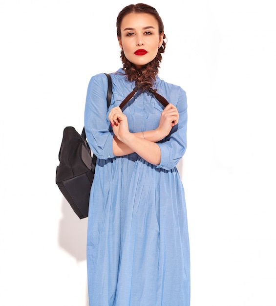 Free photo portrait of young happy smiling woman model with bright makeup and red lips with two pigtails in hands in summer colorful blue dress and backpack isolated