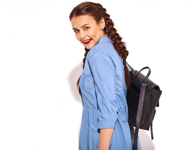 Free photo portrait of young happy smiling woman model with bright makeup and red lips with two pigtails in hands in summer colorful blue dress and backpack isolated