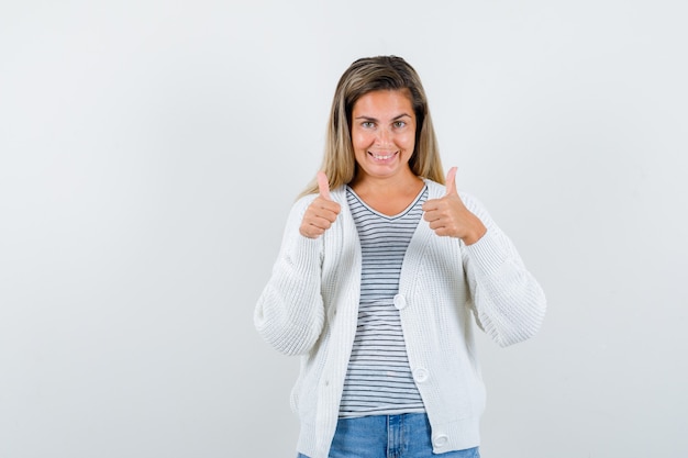 Free photo portrait of young lady showing double thumbs up in t-shirt, jacket and looking happy front view