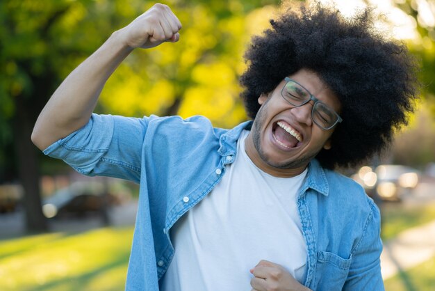 Portrait of young latin man celebrating victory outdoors. Urban concept. Success concept.