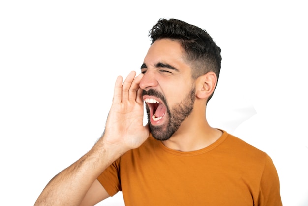 Free photo portrait of young latin man shouting and screaming against white space