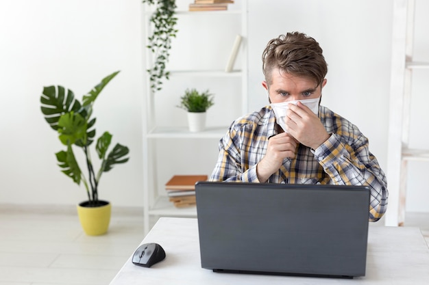 Free Photo portrait of young male arranging face mask