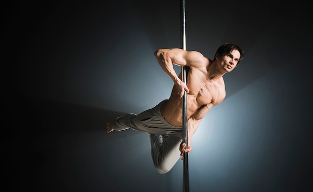 Free photo portrait of young male model pole dancing