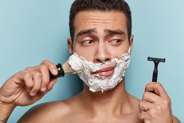 Free Photo portrait of young man applying shaving foam