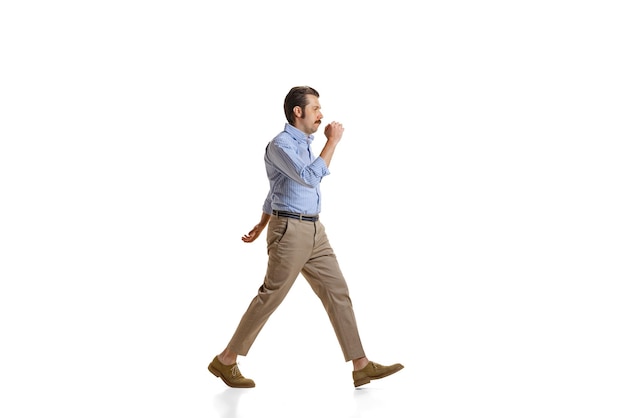 Portrait of young man businessman in official cloth walking isolated over white studio background