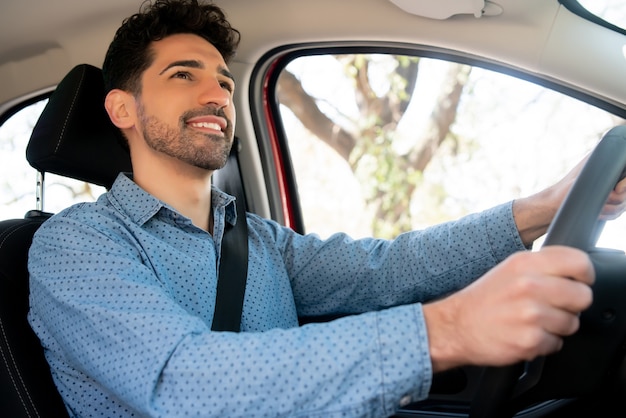 Portrait of young man driving his car on his way to work. Transport concept.