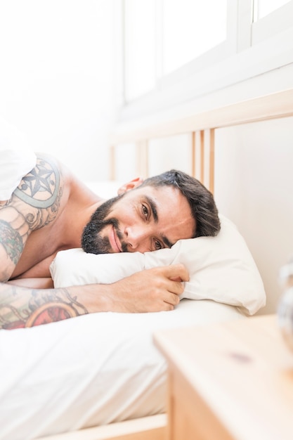 Portrait of a young man lying on bed