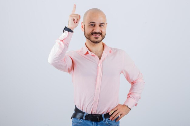 Portrait of young man pointing up