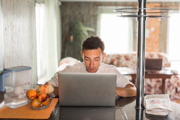 Portrait of young man using laptop at home