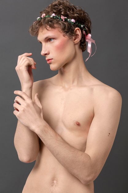 Free photo portrait young man wearing make up and floral wreath