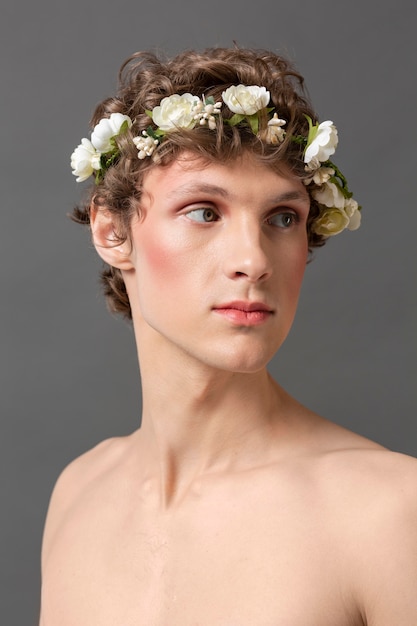 Free photo portrait young man wearing make up and floral wreath